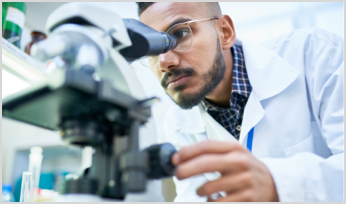 a scientist looking through a microscope