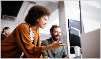two people collaborating in front of a computer